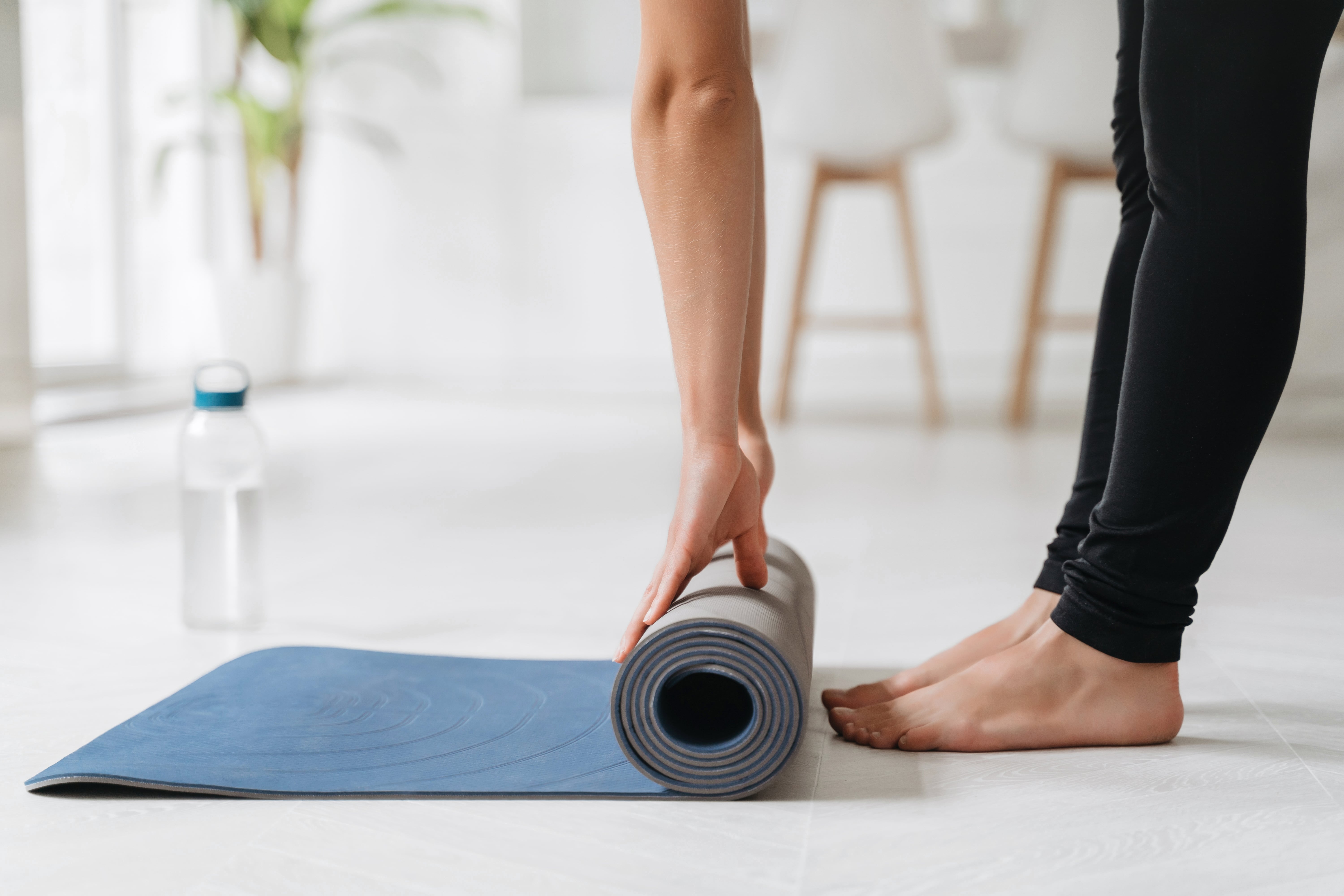 fit-girl-preparing-exercise-mat-for-yoga-session