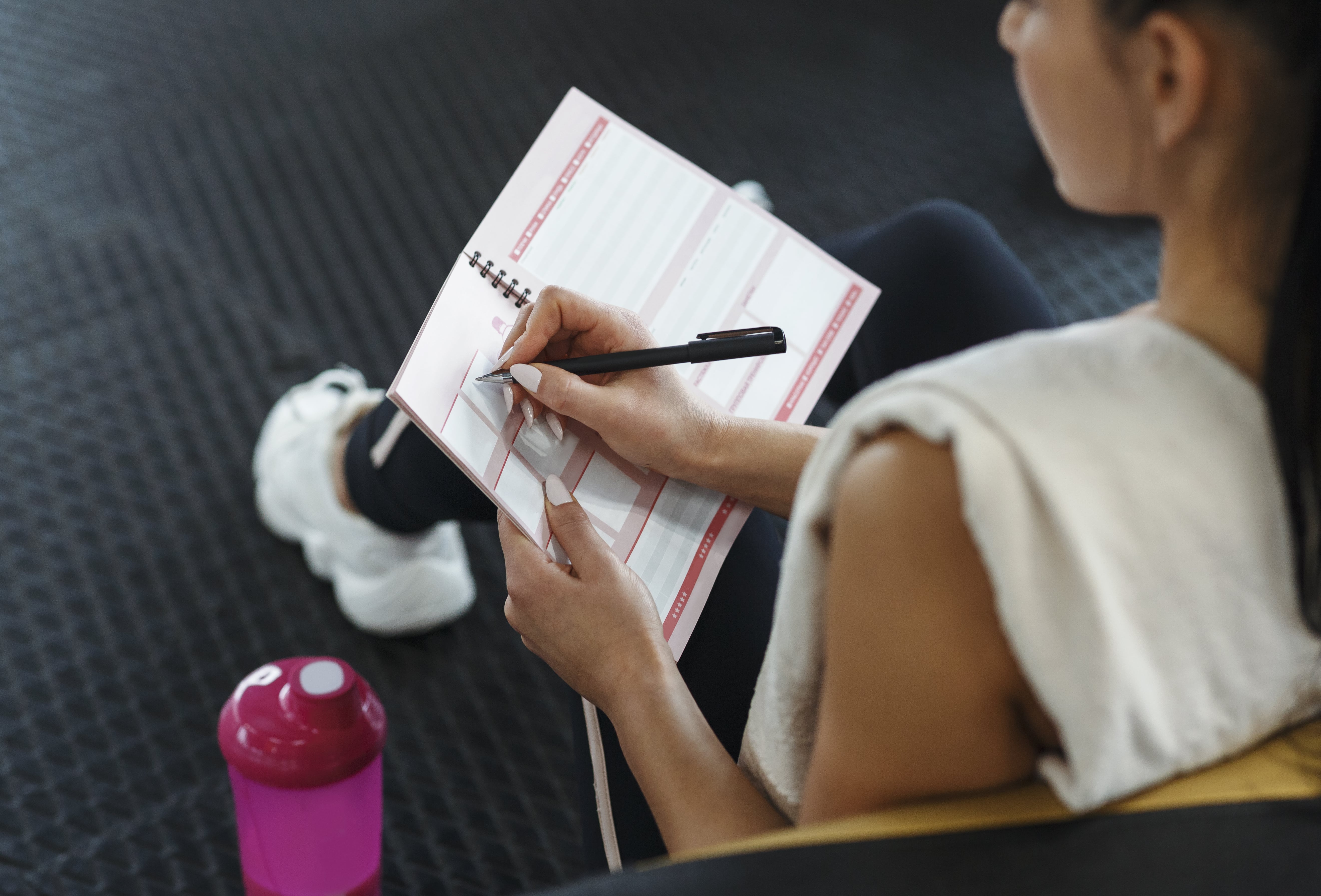 young-woman-making-her-workout-schedule-in-notebook