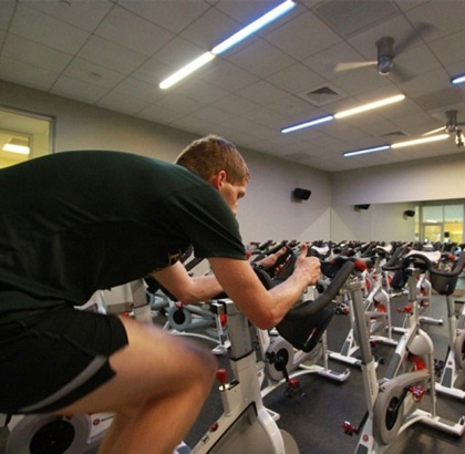 A man riding a stationary bike in a gym.