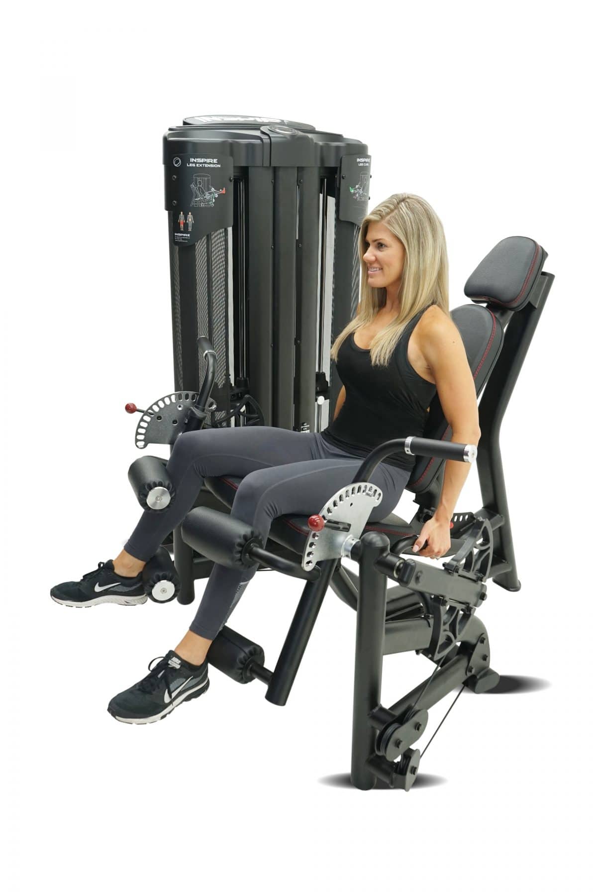 A woman is sitting on a squat machine.