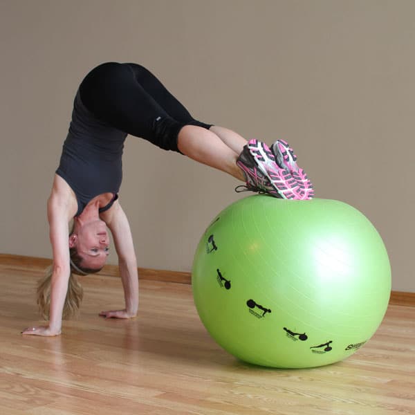 A woman doing an exercise on a green exercise ball.