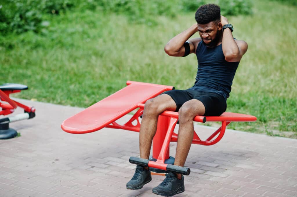 man working out in an exercise bench outside