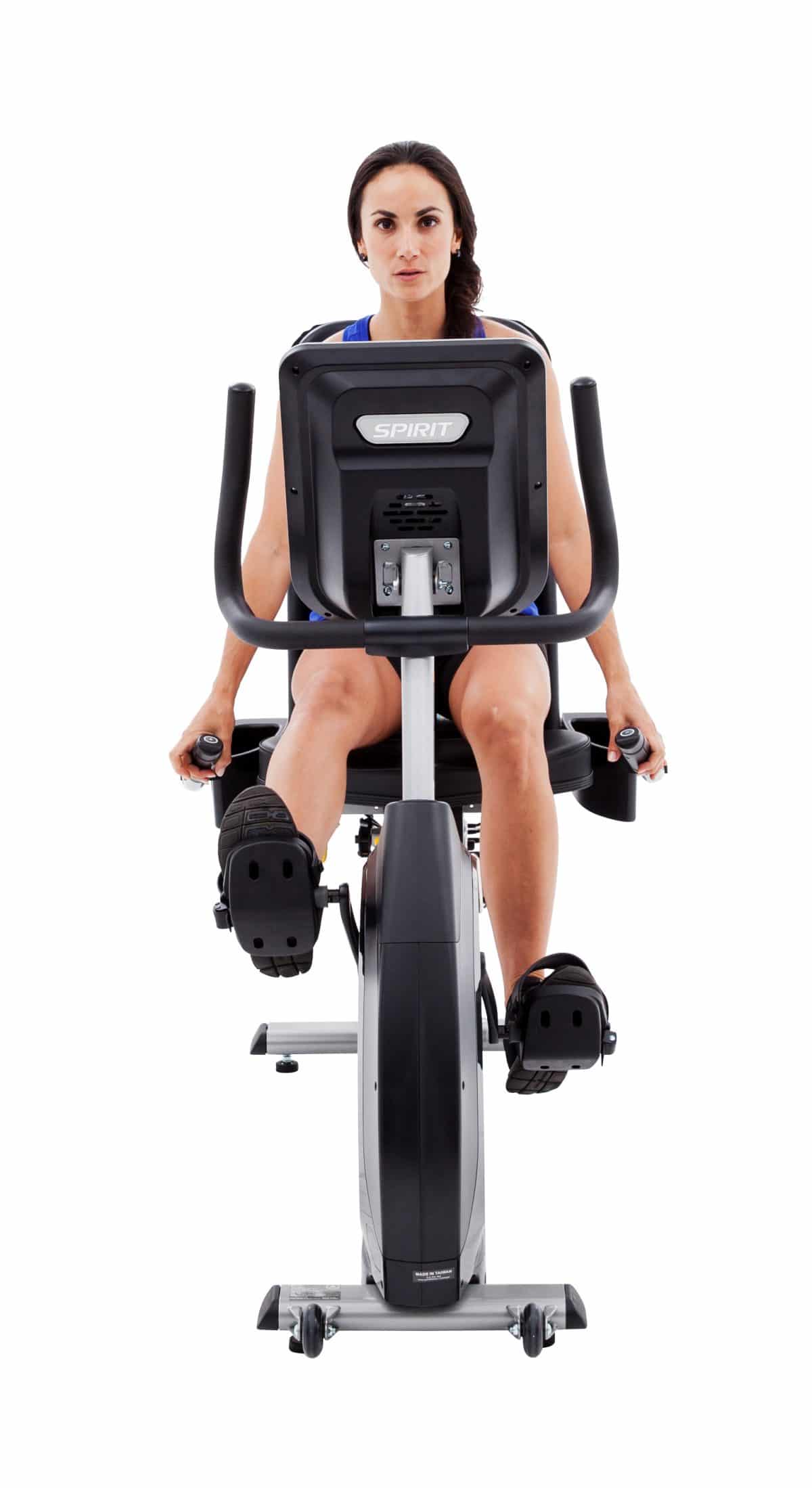 A woman riding an exercise bike on a white background.