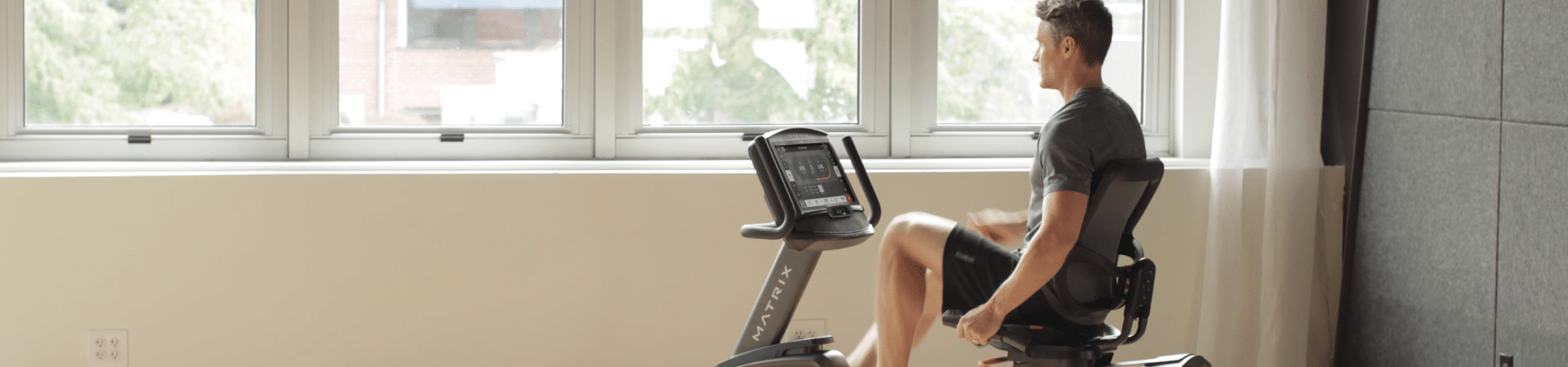 A man riding a stationary bike in front of a window