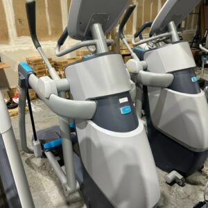 A row of stationary exercise bikes in a warehouse